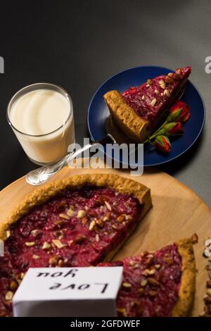 Buon San Valentino colazione per una persona cara, latte e torta su sfondo nero. Foto Stock