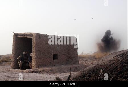 Primo Sgt. Fredrick A. Smith, primo sergente di Charlie Company, primo battaglione, terzo reggimento marino e Sgt. Harrison G. Rusk, capo sezione con la squadra combinata Anti-Armor 1, prende la copertura in un piccolo edificio di fattoria come una bomba da 500 libbre esplode su una posizione machinegun talebana e termina un fuoco Febbraio 14. I combattenti talebani iniziarono a pattugliare solo pochi minuti dopo il primo incontro tra Marines e gli anziani del villaggio dell'area dei cinque punti. Smith, 39 anni, è di Kingsland, GA., e Rusk, 23, è da Houston. Foto Stock