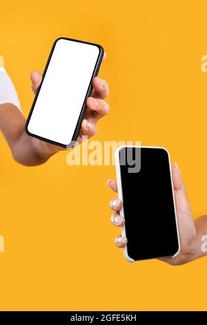 Coppia che mostra due smartphone con schermi vuoti da primo piano Foto Stock