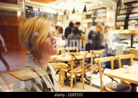 Primo piano ritratto di una donna elegante di mezza età indossare occhiali Foto Stock