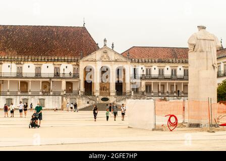 Costruzione presso l'Università di Coimbra Facoltà di giurisprudenza Piazza statua del Re turisti a piedi intorno alla piazza - Portogallo Foto Stock