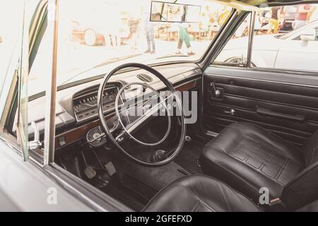 Interni di classica auto d'epoca dell'Unione sovietica. Un interno della vecchia auto retrò. Volante della vecchia auto classica. Foto Stock