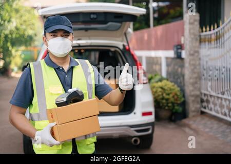 Un uomo di parto si mette in giro e indossa le maschere per prevenire la diffusione di coronavirus o COVID-19 Foto Stock