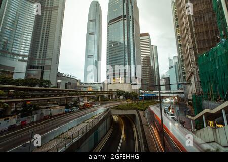 Traffico in movimento su ponte con grattacieli moderni sullo sfondo, Hong Kong Foto Stock