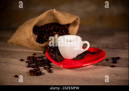 composizione del caffè con grani e tazze su superficie di legno Foto Stock