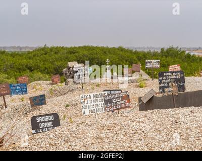 Joal-Fadiouth, Afrika - Jan, 2019: Tavolette di metallo sulla tomba del cimitero misto musulmano-cristiano. La città e il comune di Joal-Fadiouth nel Thi Foto Stock