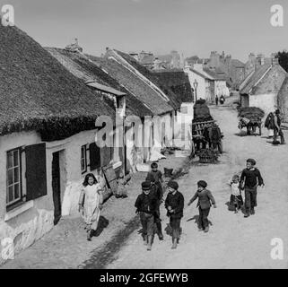 Una fotografia dei bambini dei primi anni del XX secolo a Claddagh, ex villaggio di pescatori irlandese, appena fuori dalle mura della città vecchia di Galway, dove il fiume Corrib incontra Galway Bay. Durante il 19 ° secolo il Claddagh attirato molti visitatori, ma purtroppo il villaggio originale di case con tetto di paglia è stato raso nel 1930 e sostituito da consiglio-abitazioni. Foto Stock