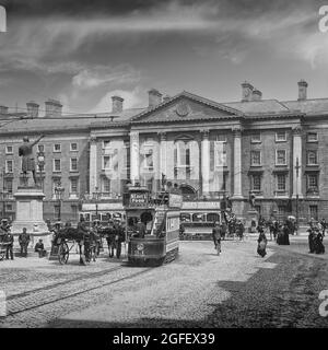 Una fotografia dei primi anni del XX secolo del Trinity College (Università) a College Green nel centro di Dublino, in Irlanda, con persone, veicoli trainati da cavalli e tram elettrici di nuova introduzione. Foto Stock