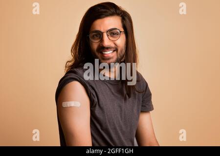 Primo piano del bel ragazzo arabo che si posa dopo la vaccinazione Foto Stock