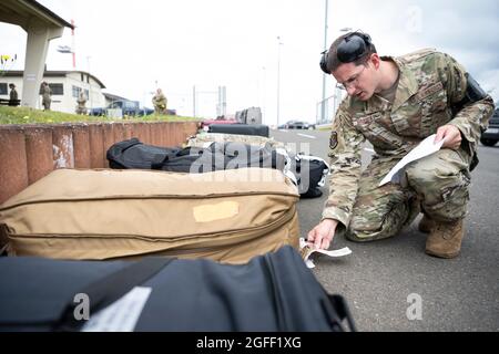 U.S. Air Force staff Sgt. Christopher Graybill, 726esimo controller Air Mobility Squadron Air Terminal Operations Center, controlla le etichette identificative sui bagagli dei passeggeri sulla base aerea di Spangdahlem, Germania, 23 agosto 2021. Il 726esimo Air Mobility Squadron, un'unità partner di Spangdahlem AB senza alcun aeromobile assegnato in modo permanente, appartiene al comando Air Mobility per l'amministrazione, ma svolge un ruolo importante nel supporto della 52a ala Fighter e delle operazioni nelle forze aeree statunitensi in Europa-Air Forces Africa. (STATI UNITI Air Force foto di Tech. SGT. Maeson L. Elleman) Foto Stock