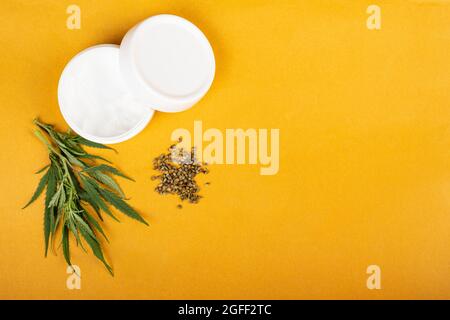 crema di semi di canapa su sfondo giallo bellezza cura della pelle. Foto Stock