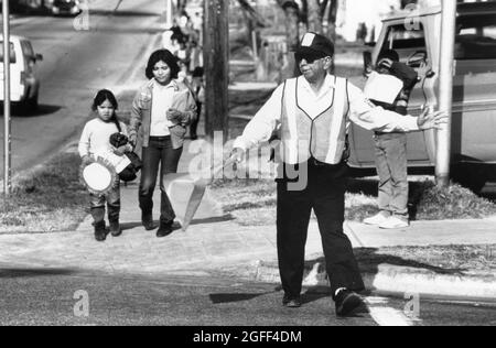 Austin Texas USA, circa 1989: L'uomo in pensione lavora come guardia di passaggio della scuola vicino alla scuola elementare dove la madre cammina per classe. Originale a colori ©Bob Daemmrich Foto Stock