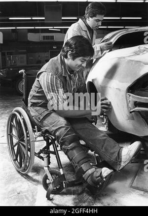 Austin Texas USA, 1990: I fratelli teen ispanici, uno in una sedia a rotelle, che fanno il lavoro del corpo dell'automobile durante una lezione del negozio dell'automobile alla loro High School. SIG. Es-0486 ©Bob Daemmrich Foto Stock