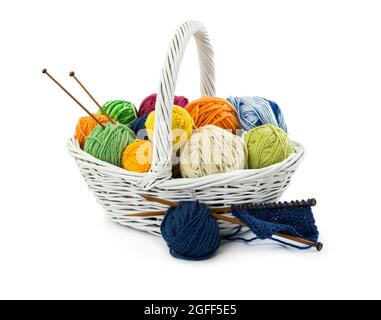 Palle di fili di lana per maglieria in cesto di vimini isolato su sfondo bianco. Foto Stock
