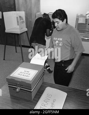 Austin Texas USA, circa 1994: Maschio di 18 anni posiziona il suo scrutinio in una casella chiusa a chiave in un luogo di votazione alla Travis High School, parte di un rinnovato impegno di voto nella contea di Travis. ©Bob Daemmrich Foto Stock