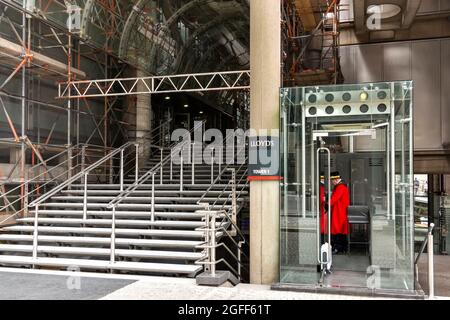 LONDON CITY LIME STREET PORTIERE IN MANTELLO ROSSO ALL'INGRESSO DEL LLOYDS BUILDING TOWER 1 Foto Stock