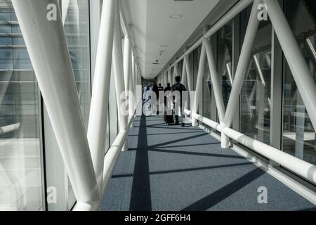 Arnavutkoy, Istanbul, Turchia - 03.08.2021: Diversi passeggeri maschi con bagagli e borse a piedi per arrivare in aereo all'aeroporto di Istanbul Foto Stock