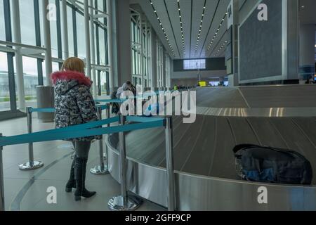 Arnavutkoy, Istanbul, Turchia - 03.11.2021: Carosello bagagli in aeroporto di Istanbul e passeggeri con maschera attendere i loro bagagli e bagagli circa Rechim Foto Stock