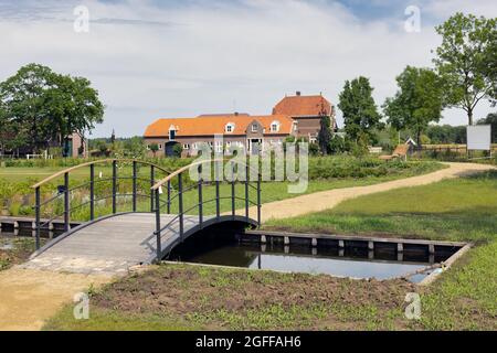 Parco pubblico olandese con piccolo canale e ponte in legno Foto Stock