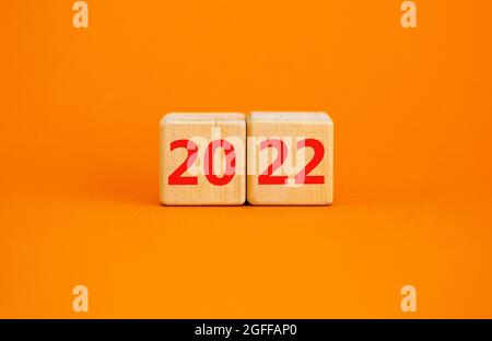 2022 felice anno nuovo simbolo. I cubi di legno simboleggiano il cambiamento dal 2021 al nuovo anno 2022. Bellissimo sfondo arancione. Spazio di copia. Business e 20 Foto Stock