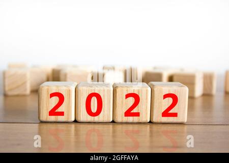 2022 felice anno nuovo simbolo. I cubi di legno simboleggiano il cambiamento dal 2021 al nuovo anno 2022. Bellissimo sfondo bianco. Spazio di copia. Business e 202 Foto Stock