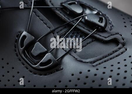 Parte di scarpe in pelle nera traforata primo piano. Macro Foto Stock