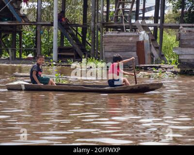 Belen, Perù- Dic 2019:Bambini in barca tra case galleggianti nella pianura alluvionale del fiume Itaya, la parte più povera di Iquitos - Belén. Venezia di la Foto Stock