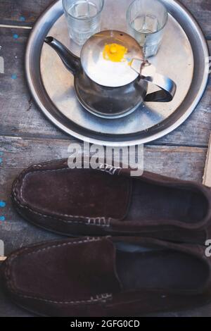 bollitore per tè marocchino con bicchieri e scarpe Foto Stock