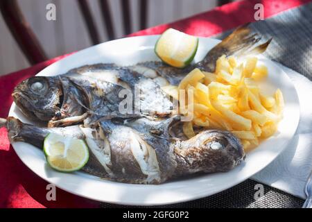 Pesce alla griglia con patatine fritte e lime, ristorante, Essaouira, Marocco Foto Stock
