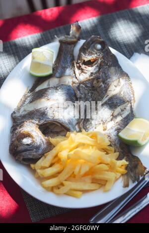 Pesce alla griglia con patatine fritte e lime, ristorante, Essaouira, Marocco Foto Stock
