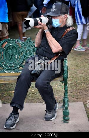 Un uomo anziano che indossa una maschera pandemica scatta foto con la sua fotocamera Sony all'annuale mercato indiano di Santa Fe, New Mexico. Foto Stock