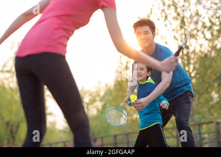 Felice famiglia giovane che gioca badminton nel parco Foto Stock