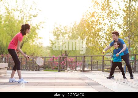 Felice famiglia giovane che gioca badminton nel parco Foto Stock