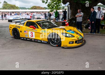 Chevrolet Corvette C6.R auto da corsa lasciando l'area di assemblaggio al Goodwood Festival of Speed Motor Racing evento 2014. Foto Stock