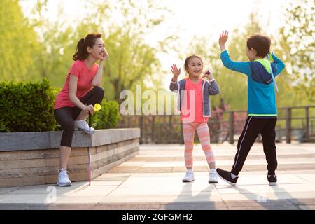 Felice famiglia giovane che gioca badminton nel parco Foto Stock