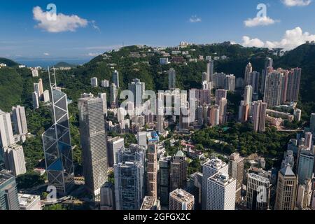 Gli alti blocchi di appartamenti residenziali di Mid-level e case di lusso sul Peak dietro gli edifici commerciali di Central, Hong Kong Island Foto Stock