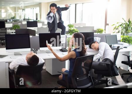 Un manager arrabbiato urlando i dipendenti attraverso il megaphone in ufficio Foto Stock