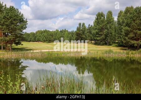 Lago circondato dal verde sul territorio del golf club. Serbatoio artificiale. Foto Stock