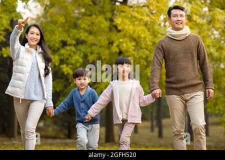 Buona famiglia giovane divertirsi nel bosco Foto Stock