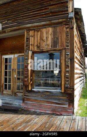 Riflesso della Schoolhouse/Masonic Temple nella finestra del palazzo (appena ad est dell'ufficio di Assay), Bannack state Park, MT. Foto Stock