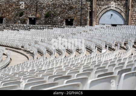 auditorium vuoto con sedie in plastica grigia in un antico anfiteatro Foto Stock