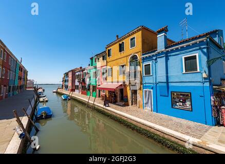 Piccolo canale con barche ormeggiate e case multicolore, colori brillanti, nell'isola di Burano, Venezia, Veneto, Italia, Europa. Foto Stock