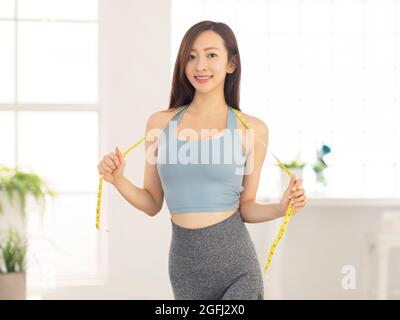 Donna sottile e misurare il nastro intorno al suo corpo.Fitness. Foto Stock