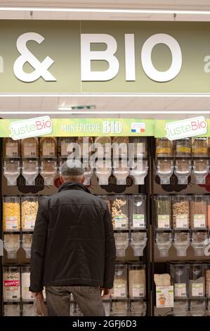 Supermercato Super U: Uomo nel mezzo della sezione di alimenti biologici, prodotti sciolti, alimentari Foto Stock