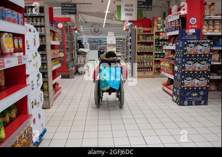 Super U supermercato: Persone disabili in sedia a rotelle in una sezione del supermercato Foto Stock