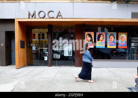 Una persona cammina accanto al Museo dei Cinesi in America, un museo di storia a Manhattan Chinatown, con i poster di odio Stop Asian nella finestra. Ago 21, 2021 Foto Stock