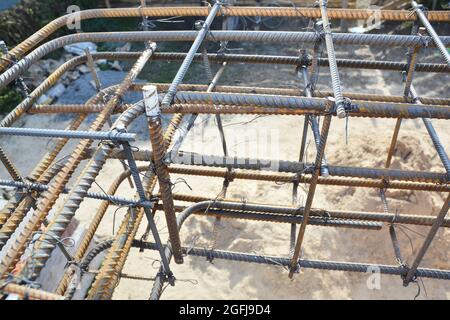 Installazione del rinforzo della barra d'acciaio, della barra di appoggio, del rinforzo del filo saldato nella costruzione della casa di calcestruzzo della fondazione. Foto Stock