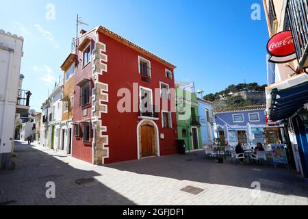 Spagna, Denia: Località balneare sul Mar Mediterraneo, provincia di Alicante. Corsia in città e facciate di case colorate, casa dipinta in rosso Foto Stock