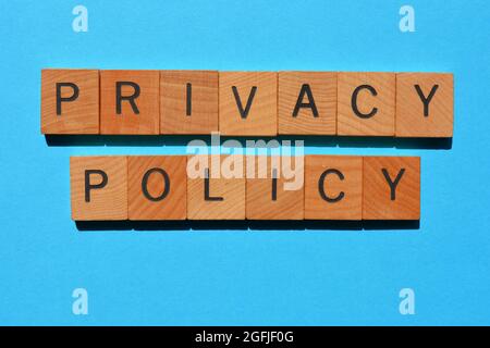 Privacy Policy, parole in lettere di legno isolate su sfondo blu Foto Stock