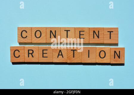 Creazione di contenuti, parole in lettere di legno alfabeto isolato su sfondo blu Foto Stock